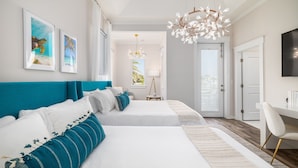 Ein modernes Hotelzimmer mit zwei Betten, einem Schreibtisch und einem Fernseher.