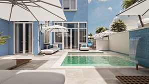 Un área de piscina moderna al aire libre con un muro de azulejos azules, una piscina pequeña y un espacio de estar con sofá y sillones.