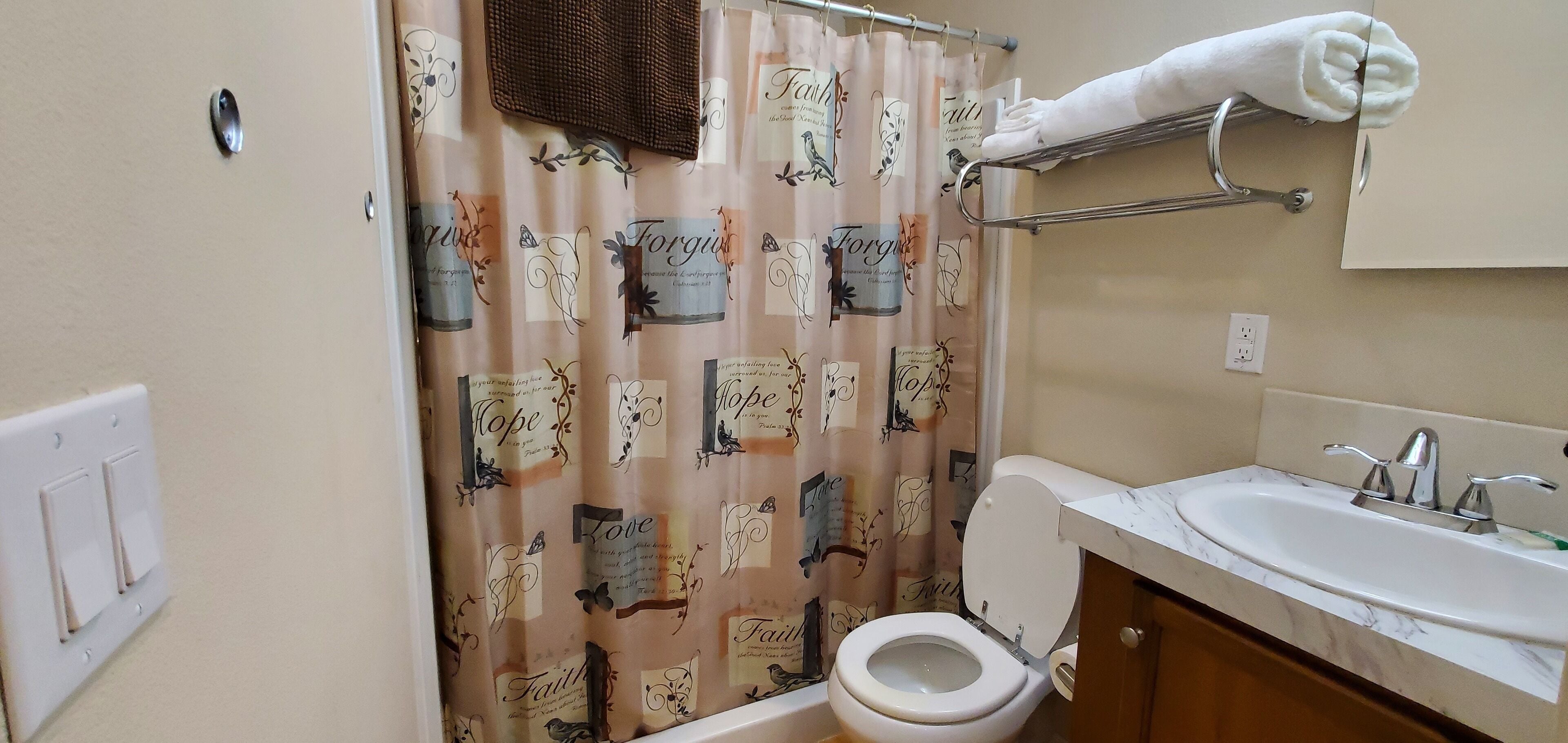 Un bagno con il water, un lavandino e un portasciugamani.