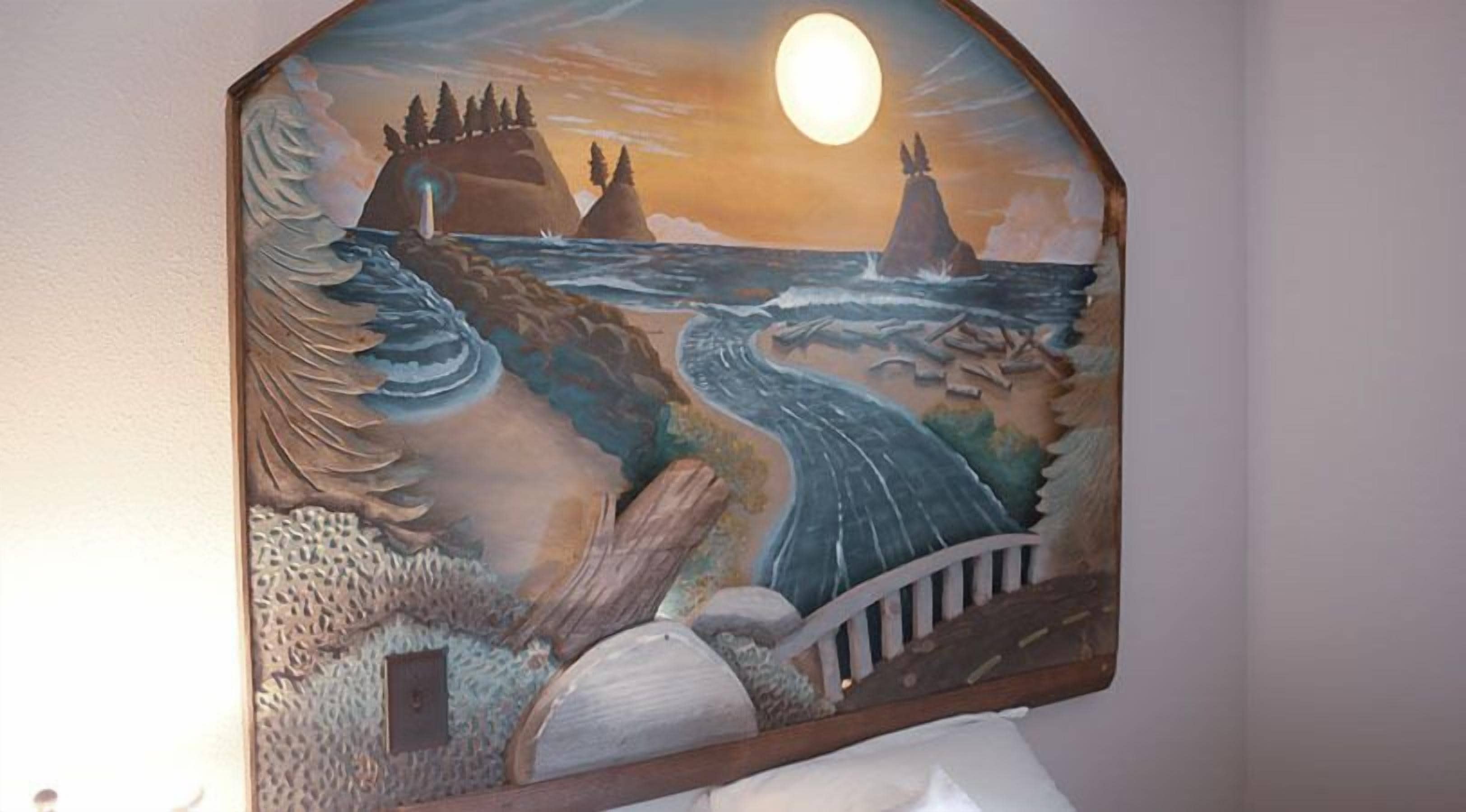 A mural with a coastal scene, including a lighthouse, waves, and a bridge.