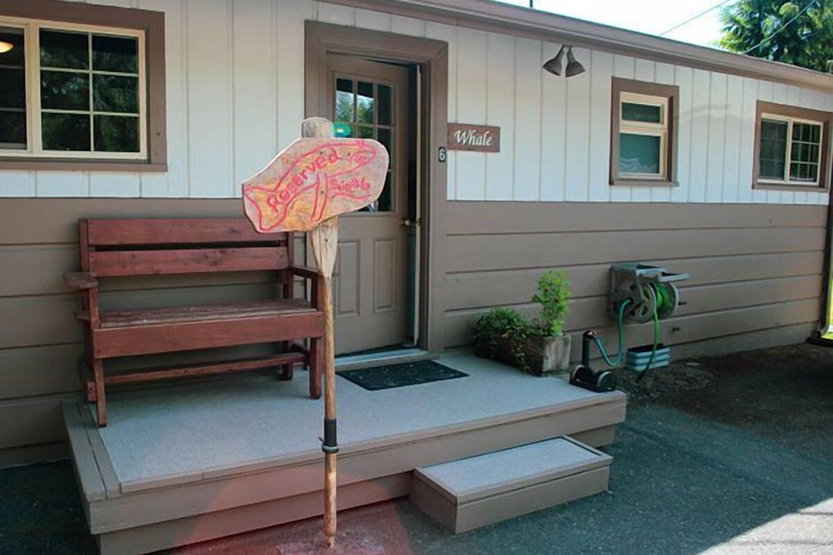 A wooden bench outside a building with a 'Whale' sign, a door, and a small porch area.