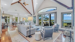 Un salón amplio con techo alto, ventanas grandes y vistas al exterior.
