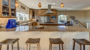 A modern kitchen with granite countertops, stainless steel appliances, and wooden cabinets. - Summer Baycation | Waterfront | Private Pool, Hot Tub (Virginia Beach)