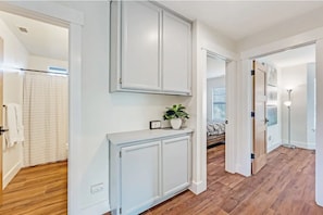 Experience a clean and inviting atmosphere in this stylish hallway, featuring a console table, potted plant, and large cabinet.
