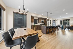 Enjoy a spacious dining area, kitchen with modern appliances, and a cozy living space with a sofa.