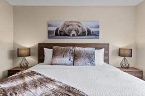 Relax in a serene space with a large bed, two bedside tables, and a framed photograph on the wall.