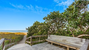 A wooden boardwalk leading to a bench overlooking a beach. - Cape Canaveral Condo W/ Direct Ocean Views, Steps to Beach, & Pool Access! ☀️ (Cape Canaveral)