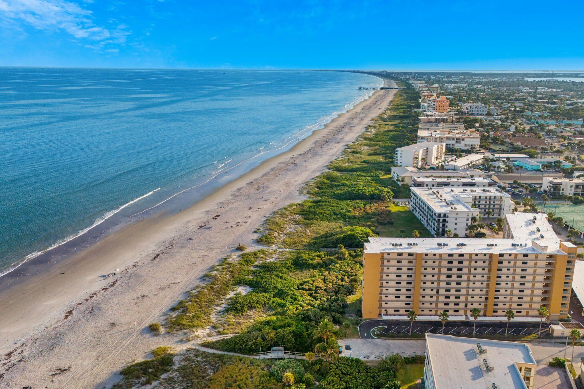 Breathtaking aerial view of the beachfront and condo property.