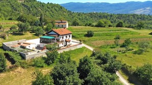A multi-story house with a garden and a view of the surrounding landscape. - Holiday flat with panoramic view and barbecue on the terrace (Gradinje)