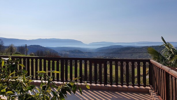 A balcony with a view of distant mountains, a railing, and some greenery. - Holiday flat with panoramic view and barbecue on the terrace (Gradinje)