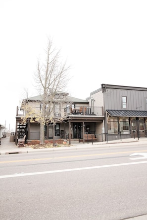 A two-story building with a balcony, a covered porch, and a storefront.