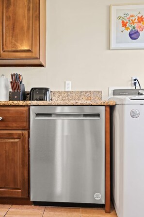 A kitchen with a dishwasher, a toaster, and a sink.