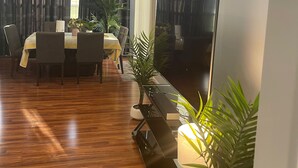 A modern living room with a dining area, wooden flooring, and potted plants. - Vacation Home in Delmar (Delmar)