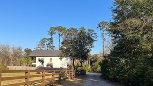A gravel path leading to a white house with a wooden fence. - Peaceful European Cottage with (Ocala)