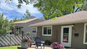 A house with a covered porch, a small deck, and a front yard with a lawn and potted plants. - Charming bungalow in the heart of Southwest Colorado (Cortez)