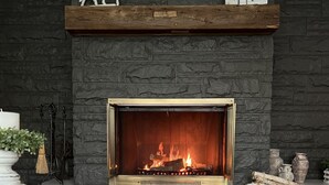A fireplace with a stone facade, a white horse sculpture above it, and a plate of grapes on a table in front. -  HOT TUB and SAUNA at 'CHIC HIDEAWAY''  Paw Paw Lake Golf club across the street (Watervliet)