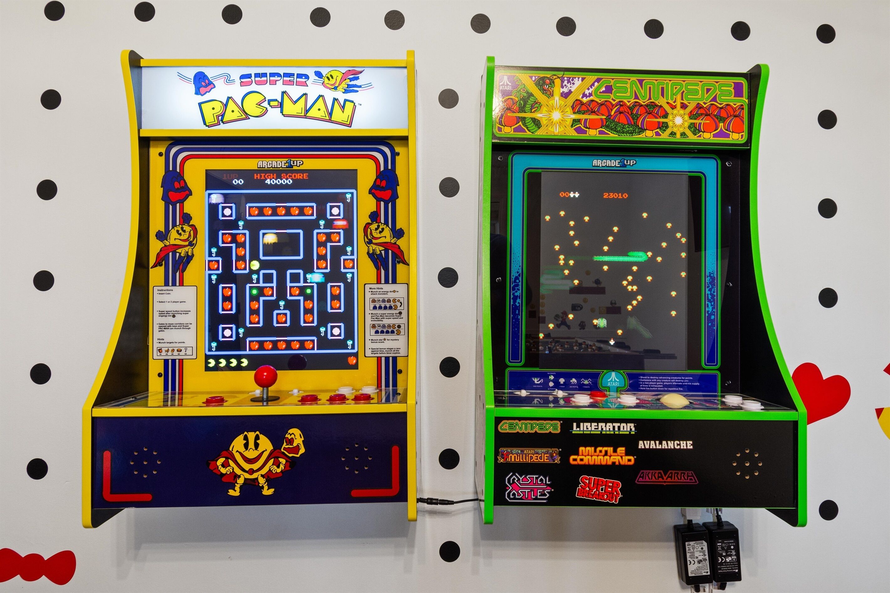 Dos máquinas de arcade, una con la etiqueta 'PAC-MAN' y la otra 'CENTIPEDE'.
