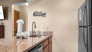 Una cucina moderna con piani di lavoro in granito, elettrodomestici in acciaio inossidabile e mobili in legno.