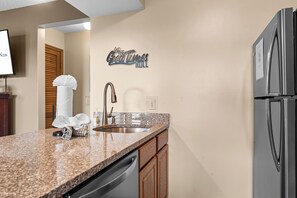 A modern kitchen with granite countertops, stainless steel appliances, and wooden cabinets. - Newly Updated Condo w Gorgeous Table Rock View_Cmty Outdoor Pool_Near Sdc_Free Tickets (Branson)