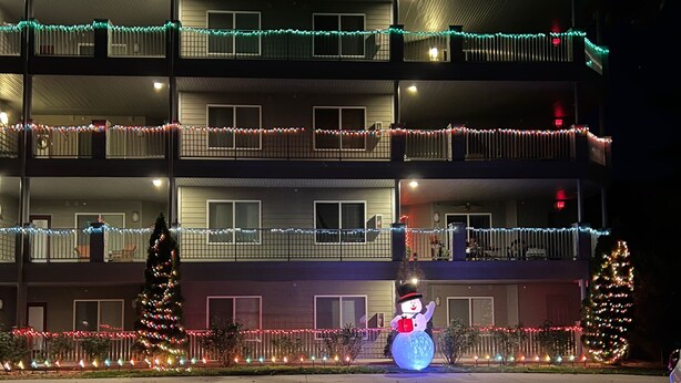 Un edificio a più piani con balconi decorati da luci colorate.