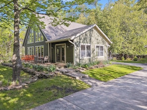 A single-story house with a porch, a small deck, and a well-maintained lawn.