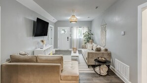 Un salon moderne avec un canapé, une table basse et un téléviseur fixé au mur.