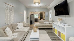 Un salon moderne avec un canapé, une table basse et un téléviseur fixé au mur.