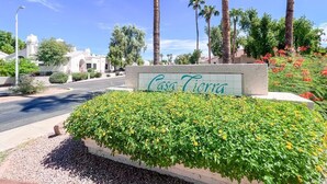 A sign for Casa Tierra with a landscaped garden and palm trees. - Southwestern Serene Oasis located in Chandler, featuring a community pool
 (Chandler)