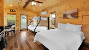 A wooden cabin with bunk beds, a dining area, and a ceiling fan. - Mt Lemmon Hotel Summerhaven Cabin 12 (Mount Lemmon)