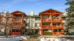 A multi-story building with a sign reading 'Snow Flower Condominiums.' - Modern home with three balconies, mountain views, and outdoor swimming pool. Walk to hiking trails (Park City)