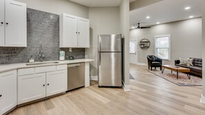 A modern kitchen with white cabinets, a stainless steel refrigerator, and a dishwasher. - 4 Bedroom Home Close to Everything (Atlanta)