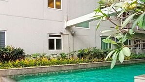 A swimming pool with a tiled edge, surrounded by a pebble border and wooden decking. - The SCENIC: Comfortable living by Awsom Phil (Manila)