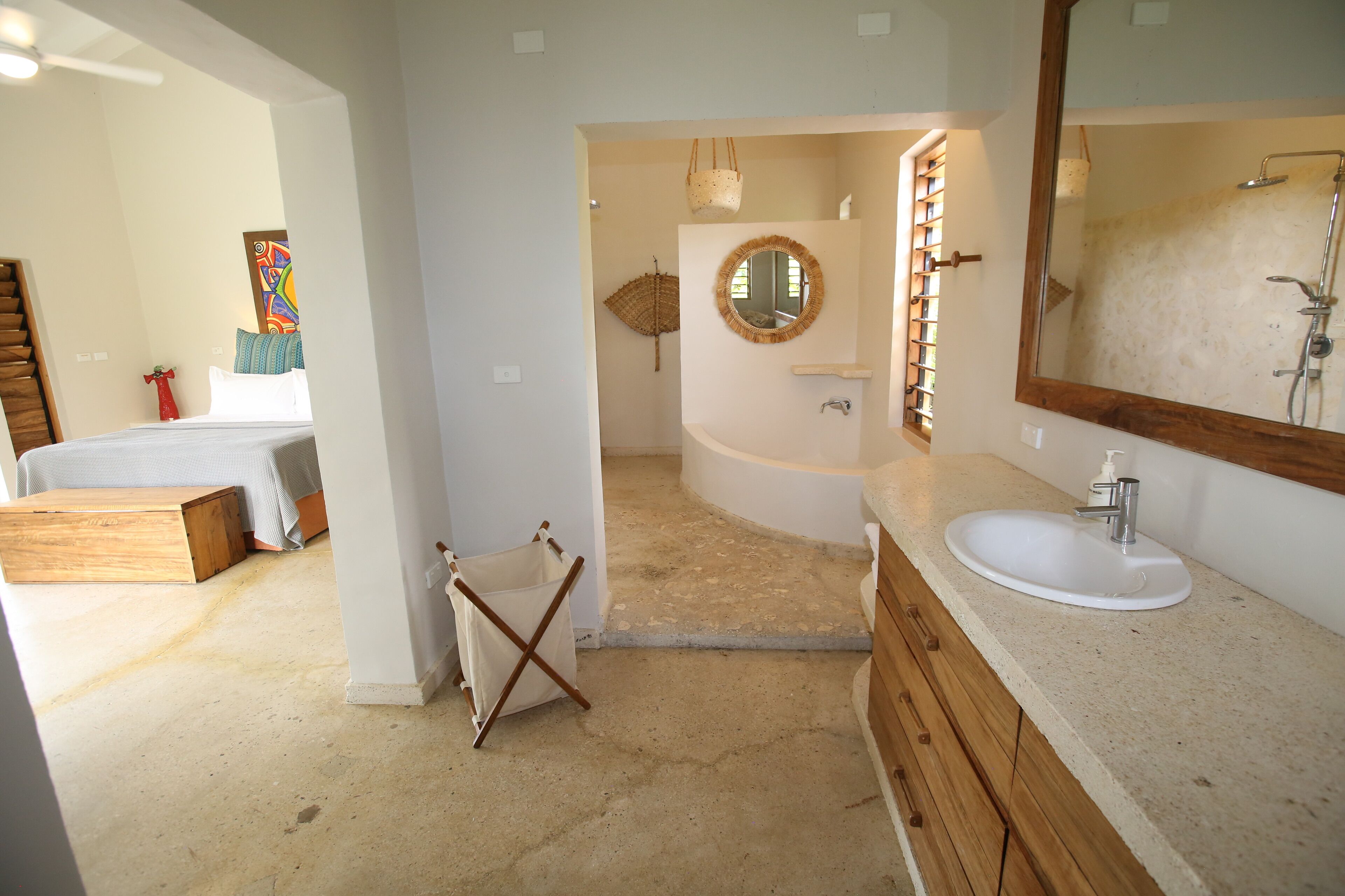 A modern bathroom with a large mirror, a bathtub, and a sink.