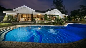 A modern house with a swimming pool, a covered patio, and a well-maintained garden. - Nakatumble (Mele)