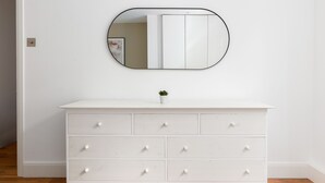A white dresser with six drawers and a small potted plant on top. - The St Johns Wood Apartment (London)