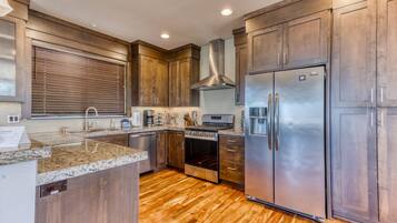 A modern kitchen with wooden cabinets, stainless steel appliances, and a central island.