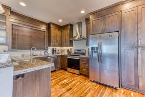 Una cocina moderna con armarios de madera, electrodomésticos de acero inoxidable y una isla central.