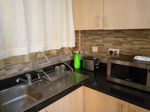 Studio Deluxe | Cuisine privée | Réfrigérateur, micro-ondes, batterie de cuisine, vaisselle et ustensiles