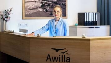 Una recepción con el logotipo "Awilla" y una fotografía enmarcada en la pared de fondo.