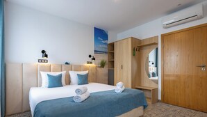 A hotel room with a bed, a wardrobe, a mirror, and an air conditioning unit. - Awilla (Ustka)