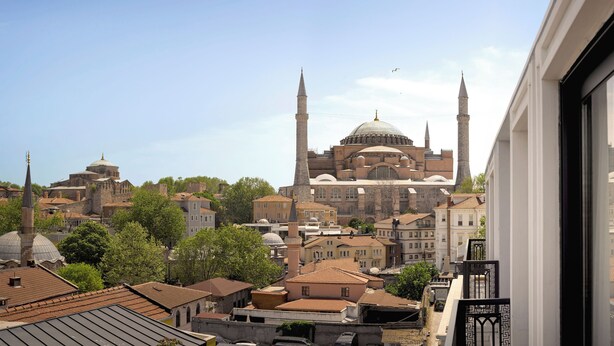 A view of a historic building with multiple domes and minarets, surrounded by other buildings and trees. - Shining Star Hotel (Istanbul)