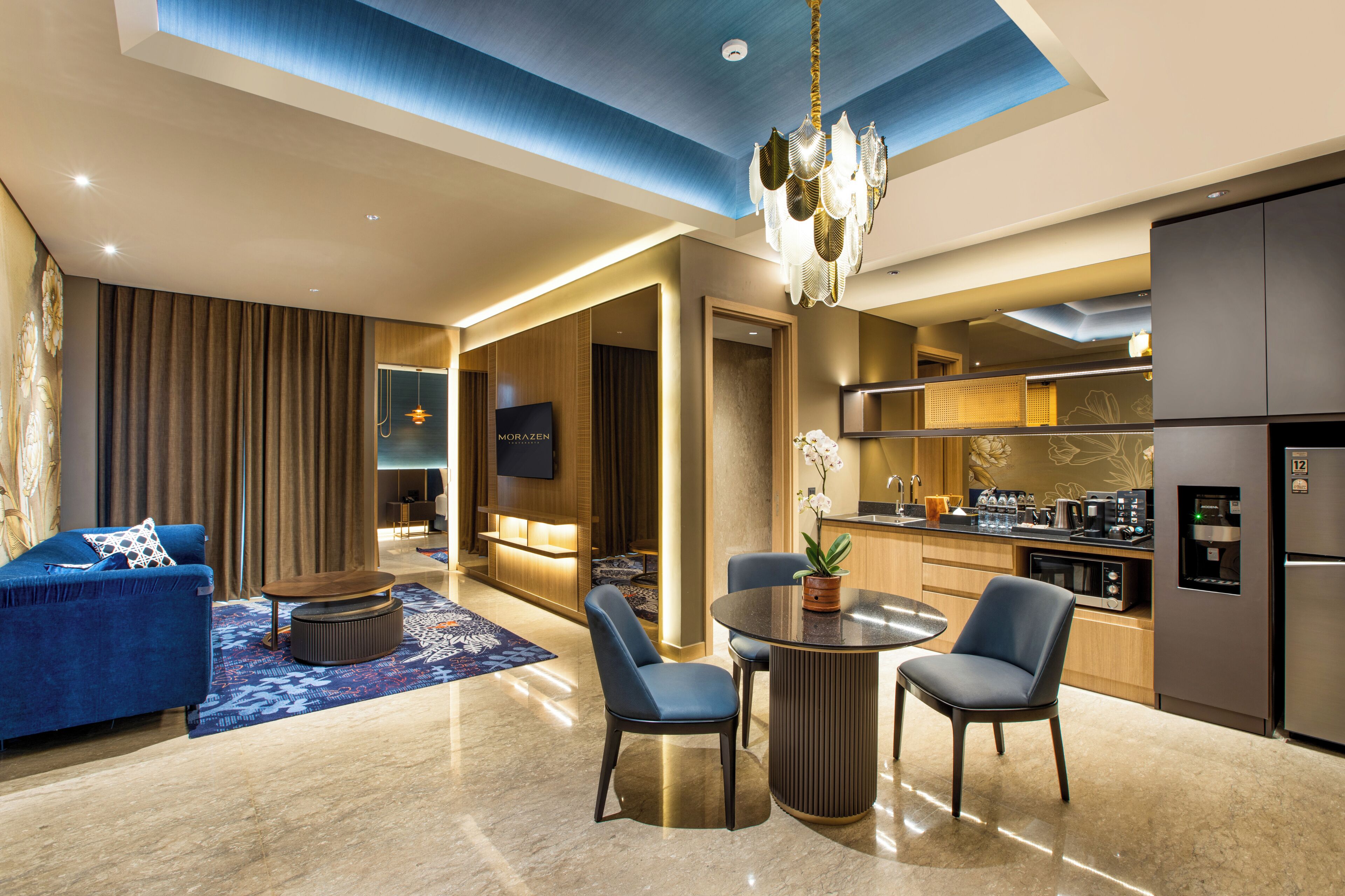 Un salon moderne comprenant un canapé, des fauteuils, une table basse et un coin repas avec une table et des chaises.