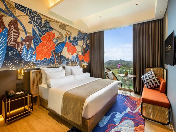 A hotel room with a large bed, a small table, a chair, a sofa, a decorative wall, and a view of the outdoors.