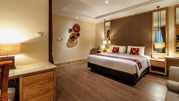 Een hotelkamer met een bed, een bureau, een stoel, een nachtkastje, een lamp en een spiegel.