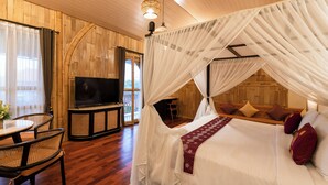 Una habitación con cama, televisión y zona de comedor.