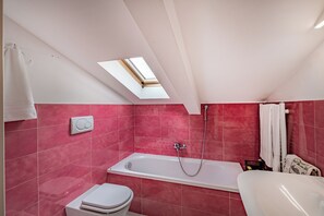 Een bad/douchecombinatie, een haardroger, een bidet, handdoeken