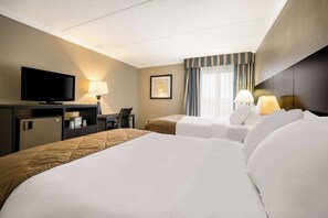A hotel room with two beds, a TV, a desk, and a chair. - Suburban Studios Syracuse Fairgrounds (Syracuse)
