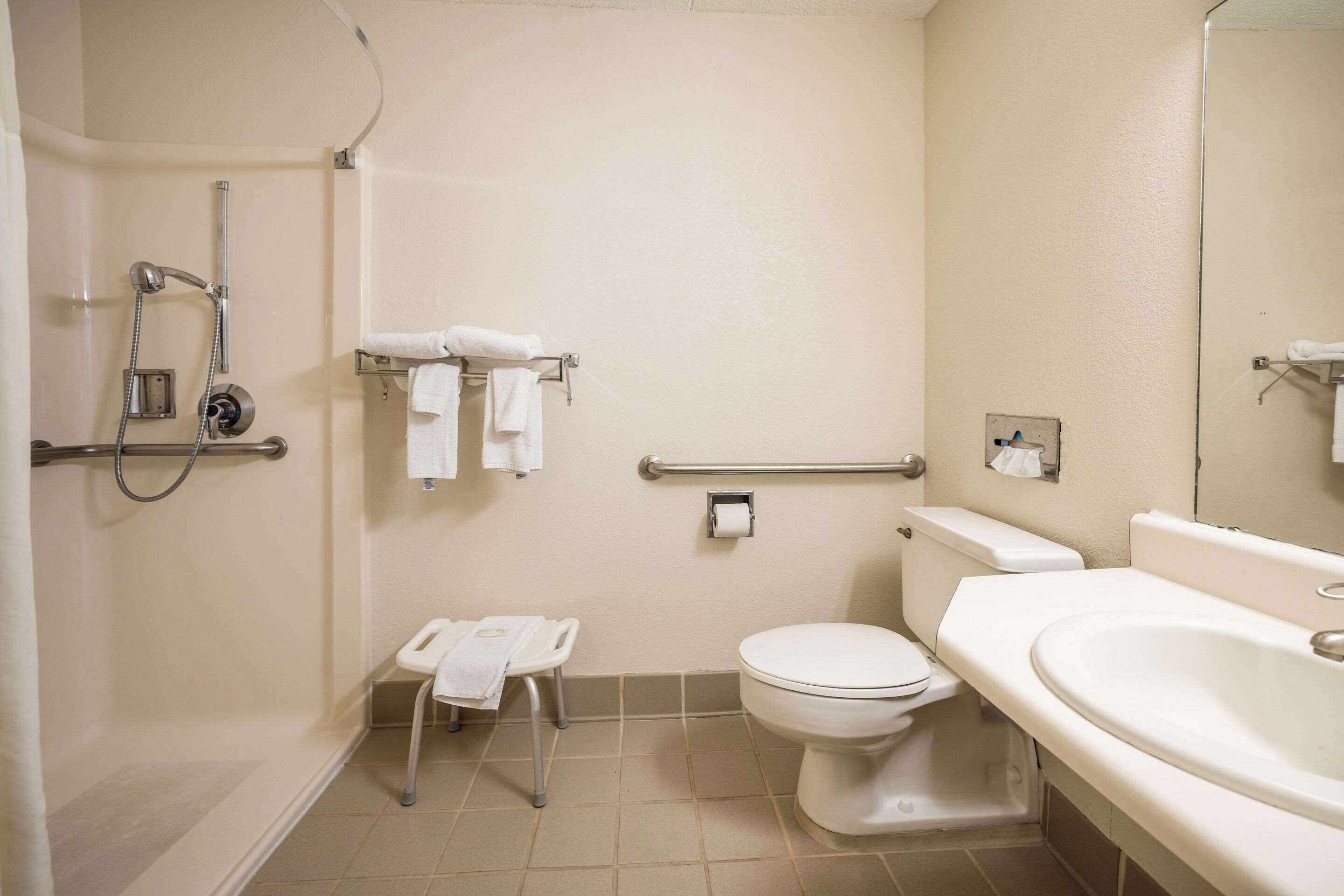 Et standard badeværelse med bruser, toilet og håndvask.