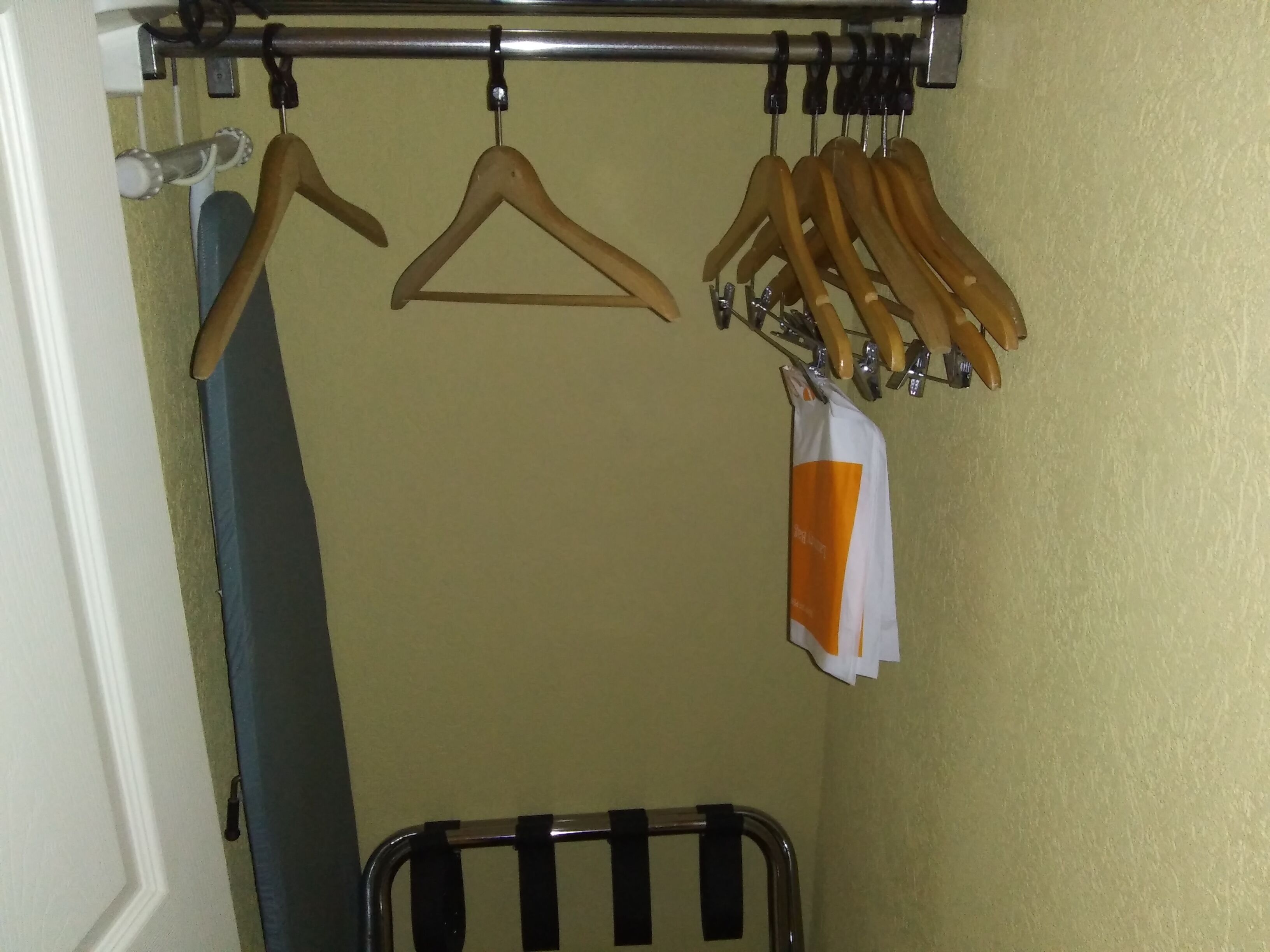 A bathroom with a towel rack, a shower curtain, and a towel rack with multiple towels.
