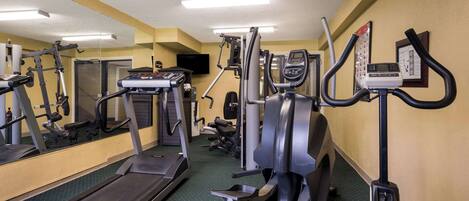 A gym with treadmills, elliptical machines, and a stationary bike.
